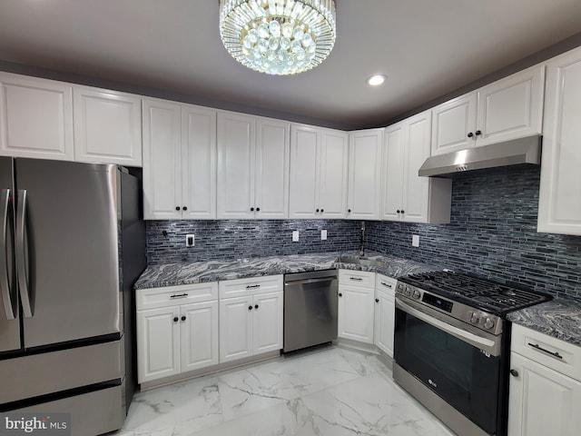 kitchen featuring appliances with stainless steel finishes, a notable chandelier, tasteful backsplash, and white cabinetry