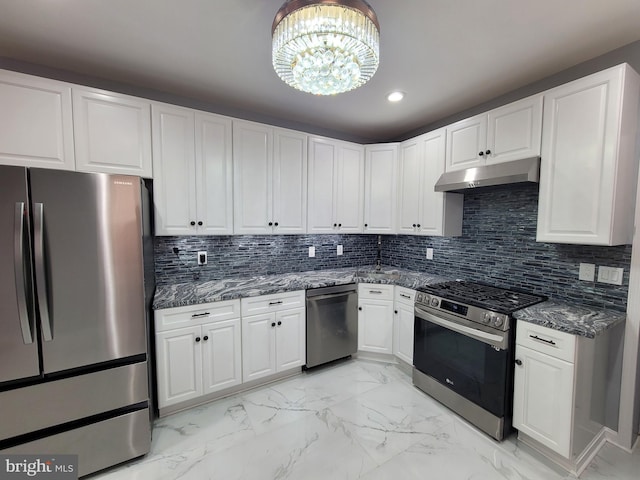 kitchen with appliances with stainless steel finishes, tasteful backsplash, white cabinetry, and a notable chandelier