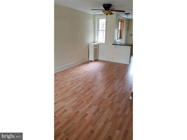 unfurnished living room featuring light wood-type flooring and ceiling fan