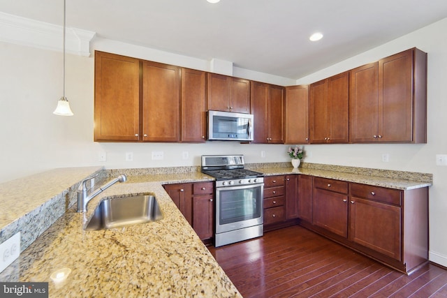 kitchen with pendant lighting, appliances with stainless steel finishes, dark hardwood / wood-style flooring, sink, and light stone counters