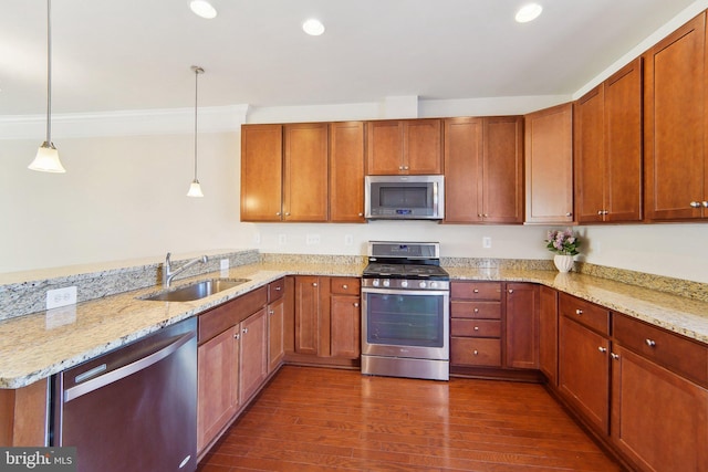 kitchen with pendant lighting, sink, dark wood-type flooring, light stone countertops, and stainless steel appliances