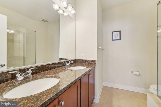 bathroom with toilet, vanity, tile patterned floors, and walk in shower