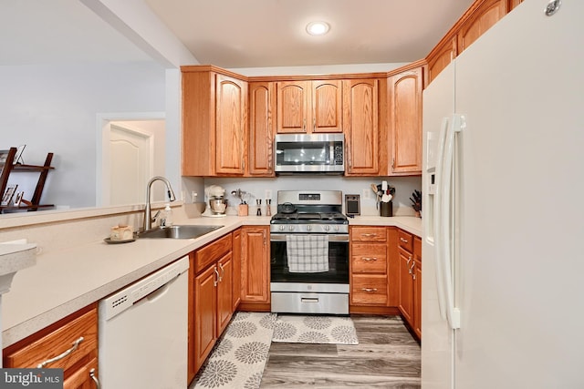 kitchen featuring stainless steel appliances, sink, and hardwood / wood-style flooring