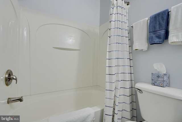 bathroom with shower / tub combo with curtain and toilet