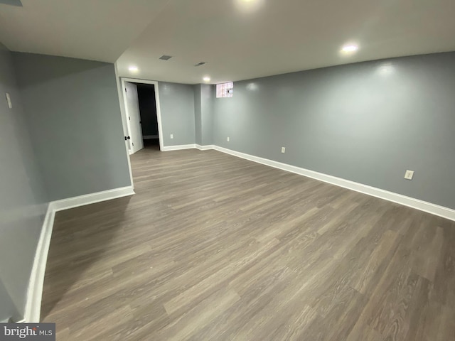 basement with dark hardwood / wood-style floors