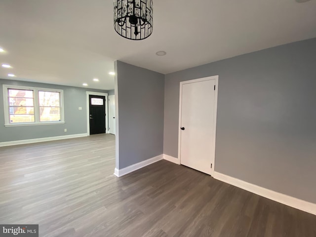 unfurnished room featuring hardwood / wood-style floors and a chandelier