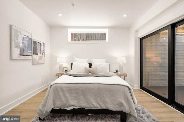 bedroom featuring light hardwood / wood-style floors and access to exterior