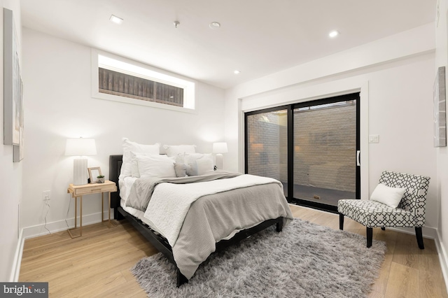 bedroom featuring light wood-type flooring and access to exterior