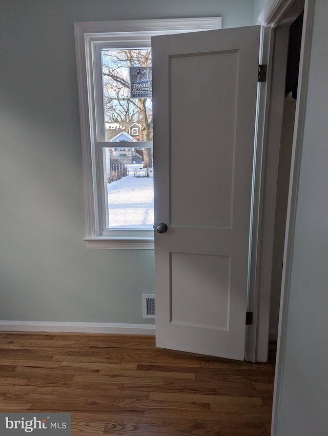 doorway with dark wood-type flooring and a healthy amount of sunlight