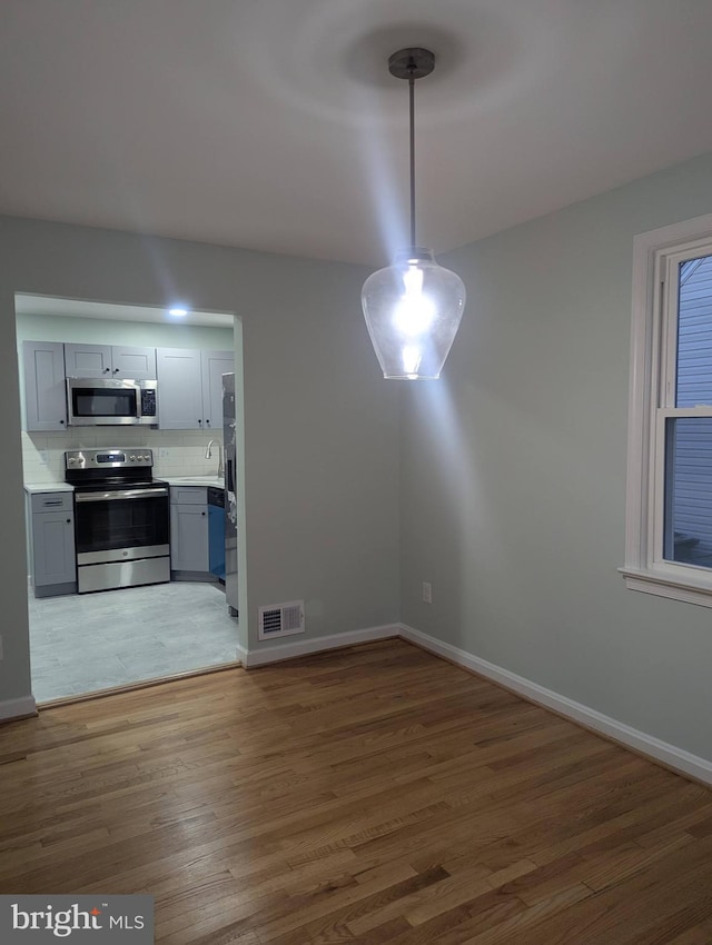 unfurnished dining area featuring dark wood-type flooring