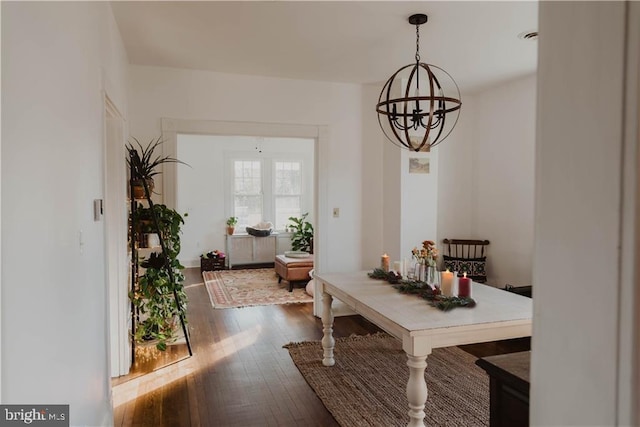 dining room with dark hardwood / wood-style flooring and a chandelier