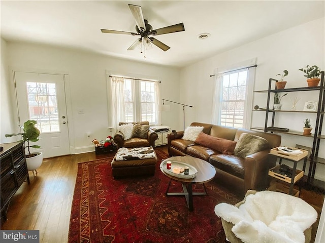 living room with dark wood-type flooring and ceiling fan