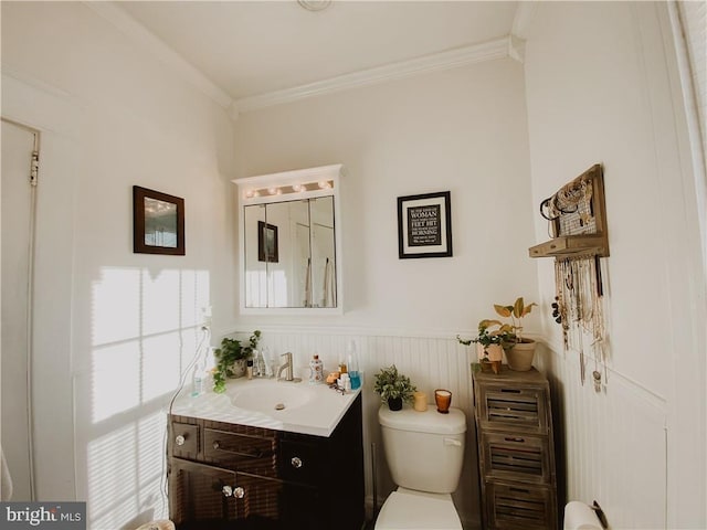 bathroom with ornamental molding, vanity, and toilet