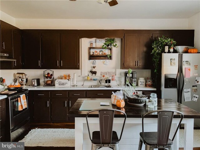 kitchen with sink, dark brown cabinets, and appliances with stainless steel finishes