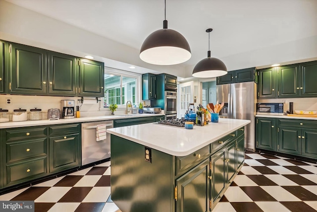 kitchen featuring stainless steel appliances, a center island, decorative light fixtures, and green cabinets