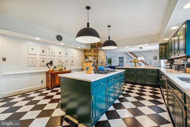 kitchen featuring stainless steel gas stovetop, hanging light fixtures, sink, and a kitchen island