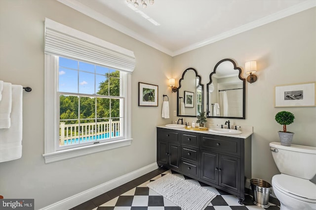 bathroom featuring toilet, vanity, and ornamental molding