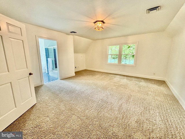 bonus room with carpet flooring and vaulted ceiling