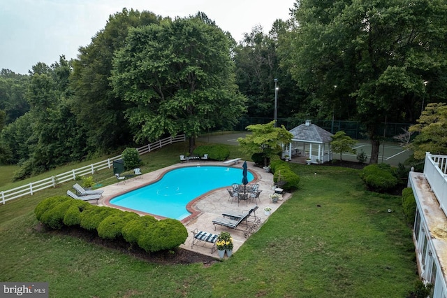 view of swimming pool with a lawn, an outbuilding, and a patio area