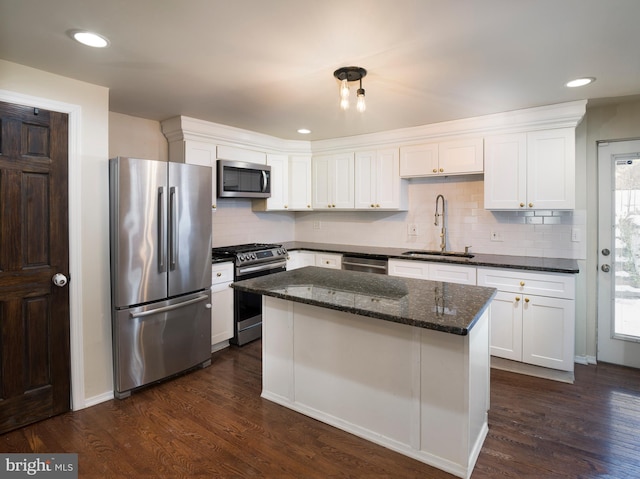 kitchen featuring sink, dark wood-type flooring, appliances with stainless steel finishes, white cabinets, and dark stone counters