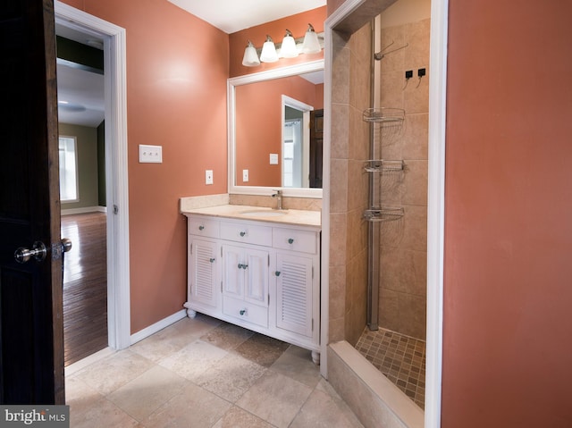 bathroom with tiled shower and vanity