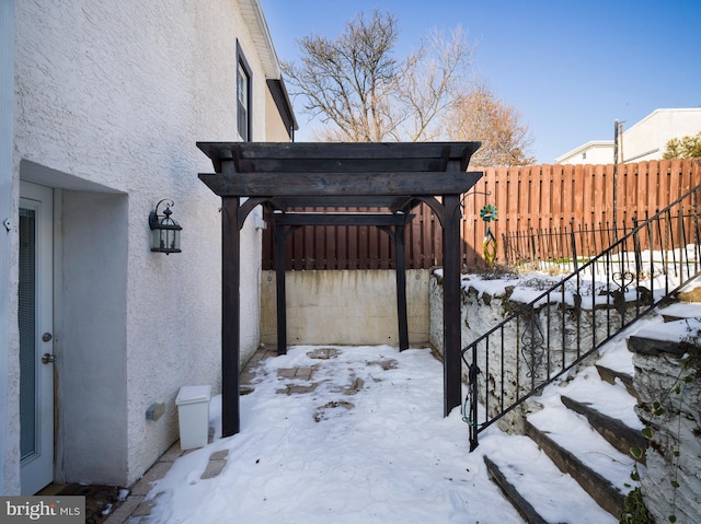 snow covered patio featuring a pergola