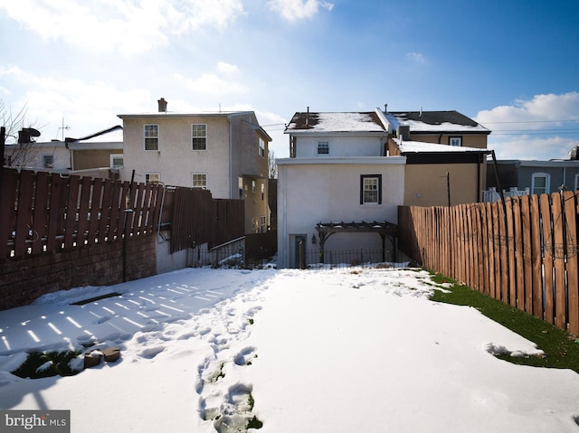 view of snow covered back of property