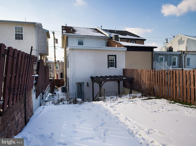 snow covered house featuring a pergola