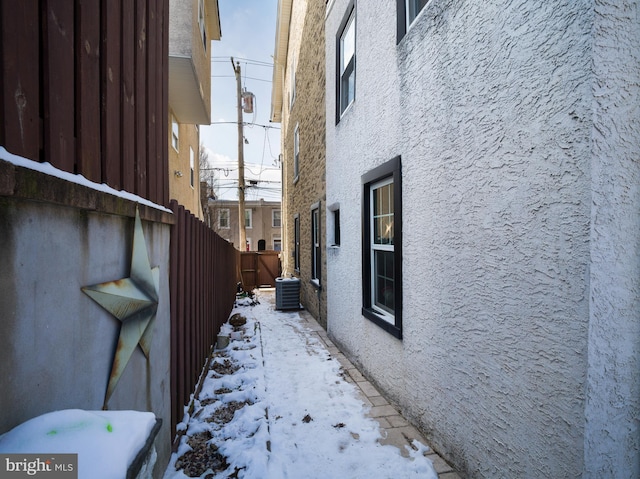 view of snow covered exterior with central AC