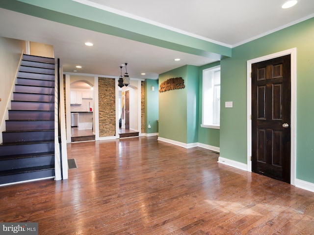 unfurnished living room featuring crown molding and wood-type flooring