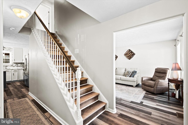 stairs with hardwood / wood-style flooring and a textured ceiling