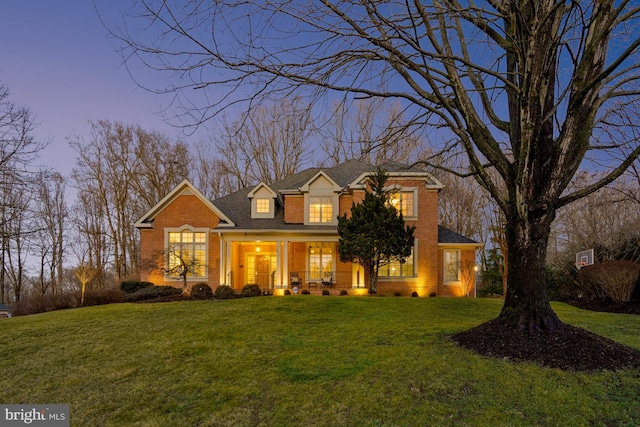 view of front of house featuring covered porch and a lawn