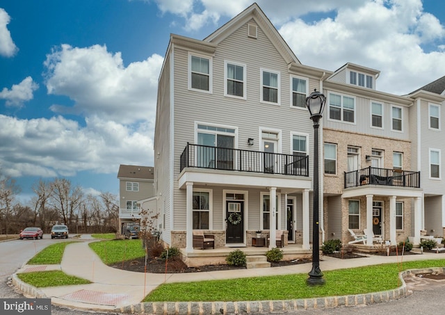 view of property with a balcony and a porch