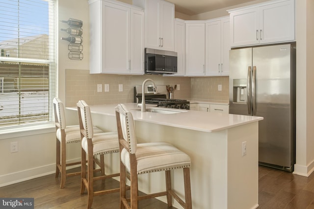 kitchen featuring sink, white cabinetry, appliances with stainless steel finishes, and dark hardwood / wood-style flooring