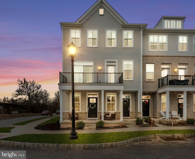 townhome / multi-family property featuring a balcony and a porch