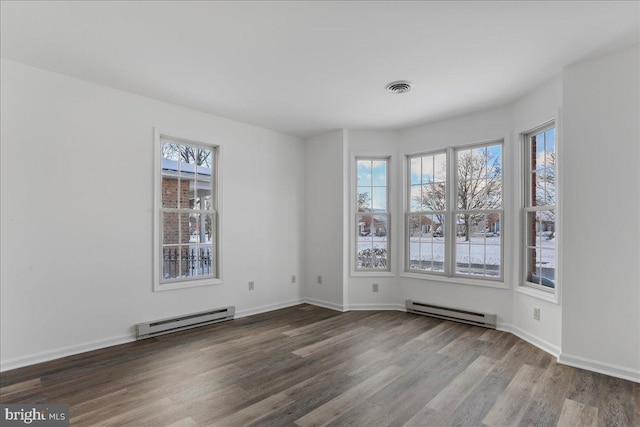 spare room featuring a baseboard radiator and hardwood / wood-style flooring