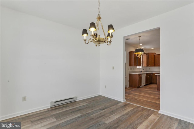 unfurnished dining area featuring sink, baseboard heating, dark wood-type flooring, and a chandelier