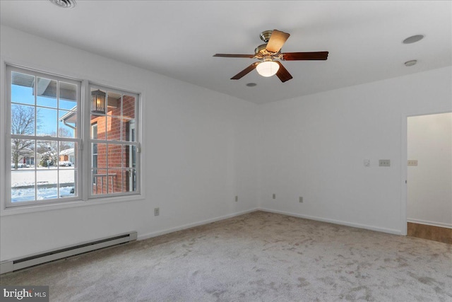 carpeted empty room with ceiling fan and a baseboard heating unit