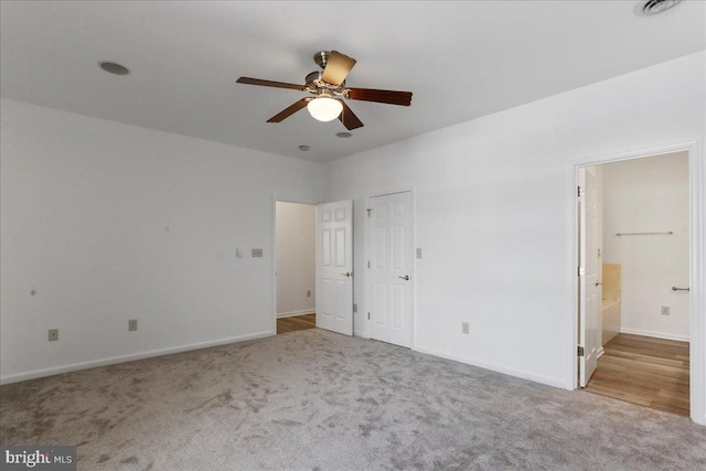 unfurnished bedroom with light carpet, connected bathroom, and ceiling fan