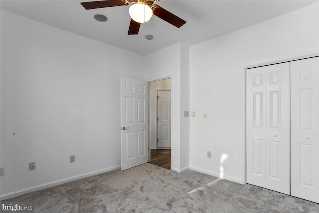 unfurnished bedroom with ceiling fan, a closet, and light carpet