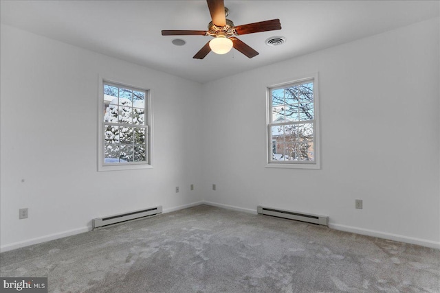 empty room featuring ceiling fan, light colored carpet, and a baseboard heating unit