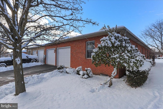 view of snowy exterior with a garage