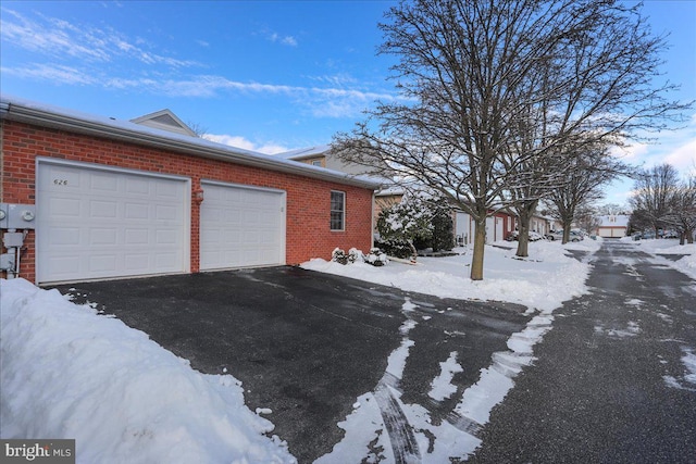 view of snow covered exterior with a garage