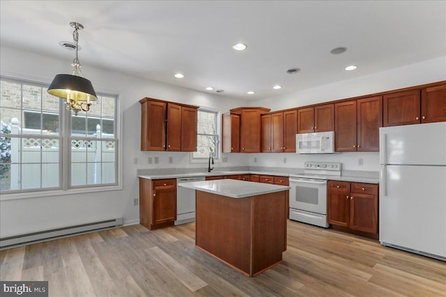 kitchen featuring a baseboard radiator, decorative light fixtures, light wood-type flooring, white appliances, and a center island