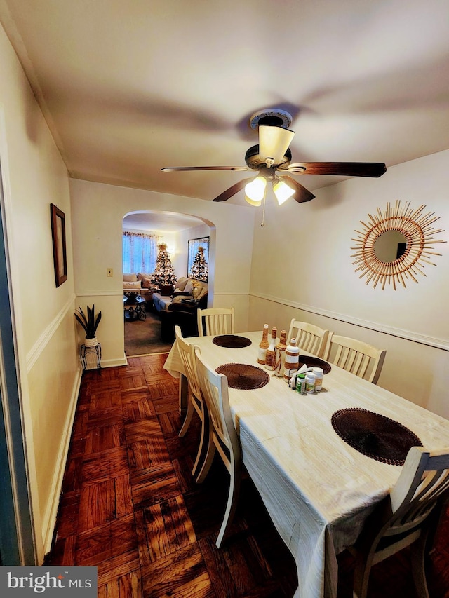 dining space with dark parquet flooring and ceiling fan