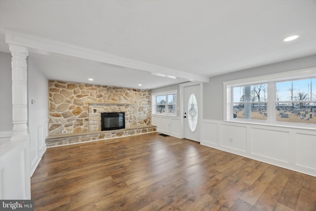 foyer featuring dark wood-type flooring and a stone fireplace