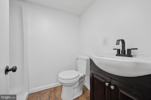 bathroom featuring toilet, wood-type flooring, and vanity