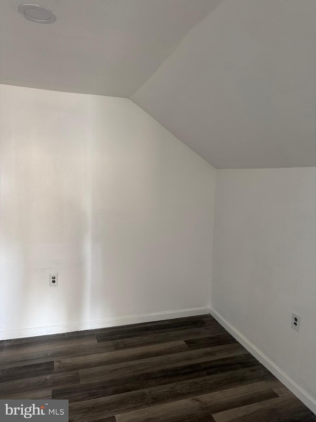 bonus room with dark hardwood / wood-style flooring and vaulted ceiling