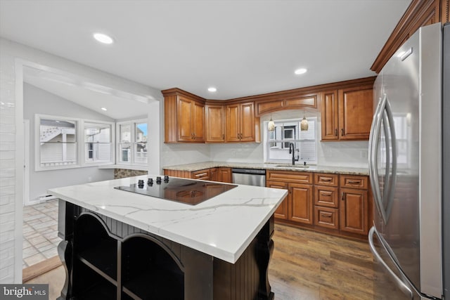 kitchen with sink, a kitchen breakfast bar, tasteful backsplash, light stone countertops, and appliances with stainless steel finishes