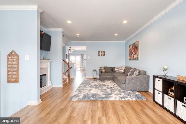 living room featuring light hardwood / wood-style floors, crown molding, and ceiling fan